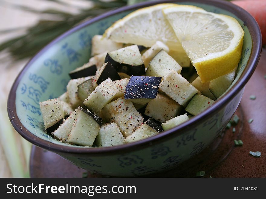 Fresh pieces of aubergines in a bowl with lemon