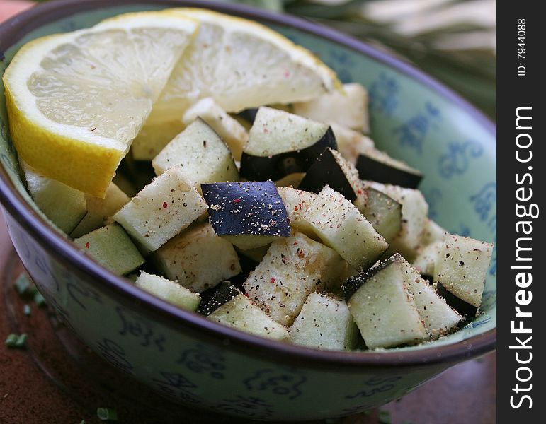 Fresh pieces of aubergines in a bowl with lemon