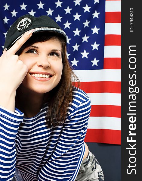 Young sailor standing opposite an American flag