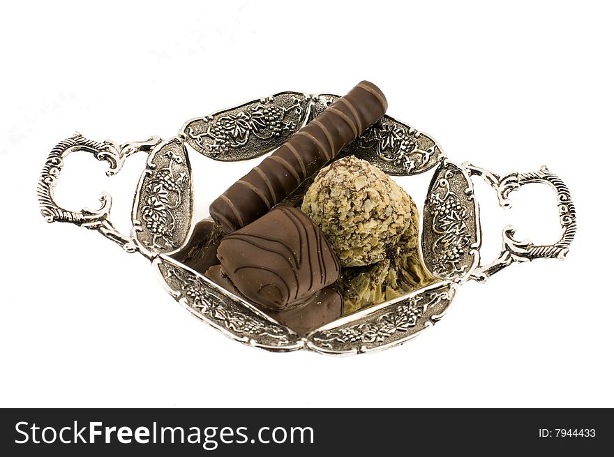 Chocolate sweet which lay on silver saucer. Chocolate sweet which lay on silver saucer