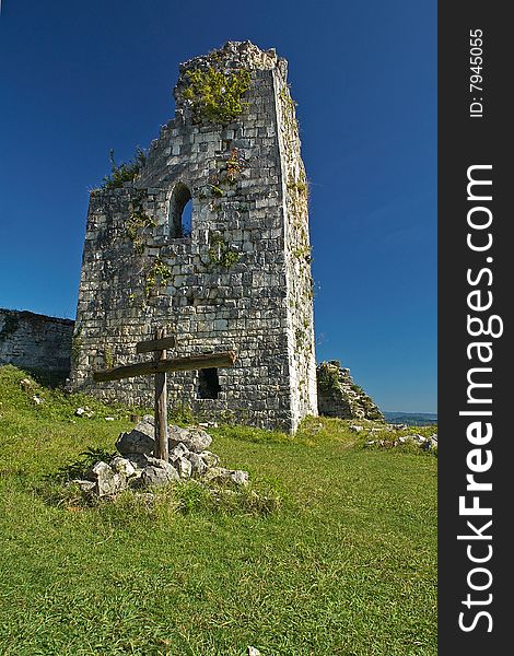 Ancient tower and a cross on the top of the mountain