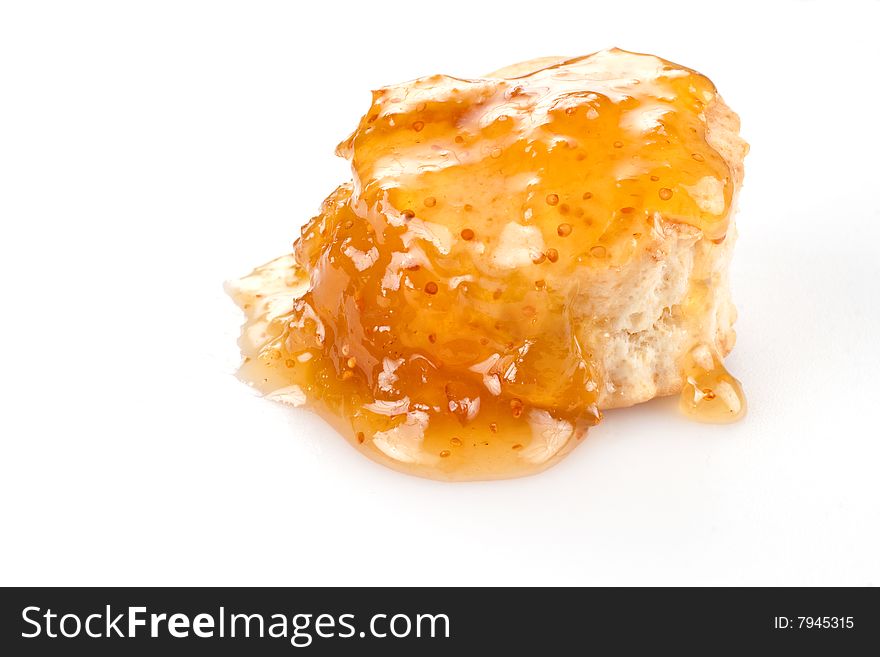 A single small baking powder biscuit covered with fig preserves. A single small baking powder biscuit covered with fig preserves