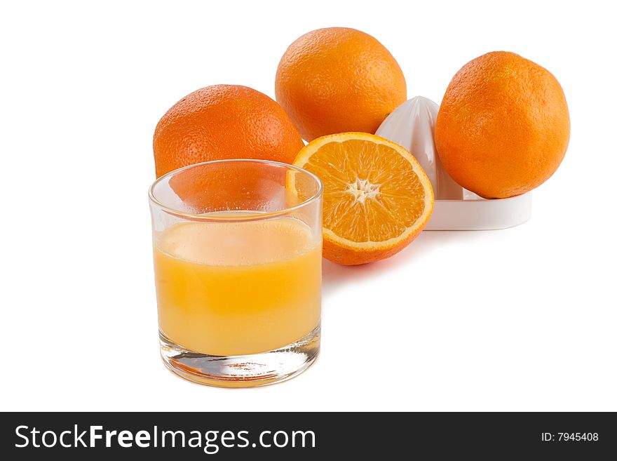 Glass of fresh orange juice with oranges and a juicer