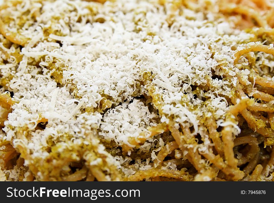 Some spaghetti with italian homemade pesto and raped dry parmesan cheese. Some spaghetti with italian homemade pesto and raped dry parmesan cheese