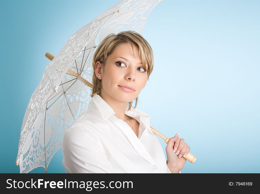 Portrait of attractive woman with lacy sunshade umbrella over blue background. Portrait of attractive woman with lacy sunshade umbrella over blue background