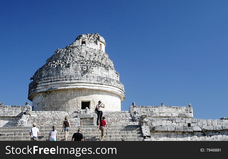 Tourists walking up stone steps of this mayan temple ruin. Tourists walking up stone steps of this mayan temple ruin