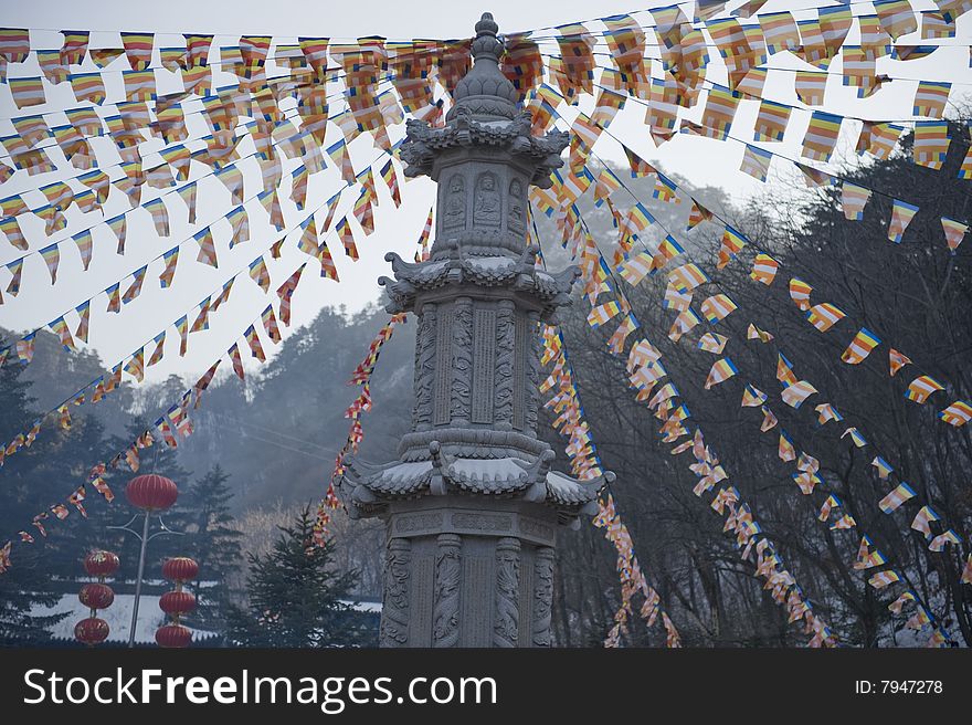 People decorated the buddha tower on the square and  burn joss sticks in the front yard of temple when they do some religious affairs in China.