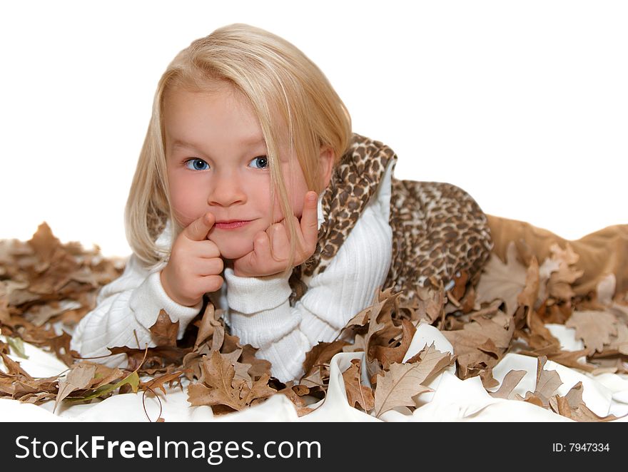 Cute young girl in a jacket, laying in leaves, pointing. Cute young girl in a jacket, laying in leaves, pointing