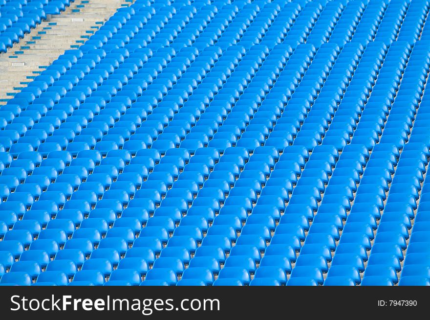 Rows and rows of blue stadium seats on an incline creating an urban abstract