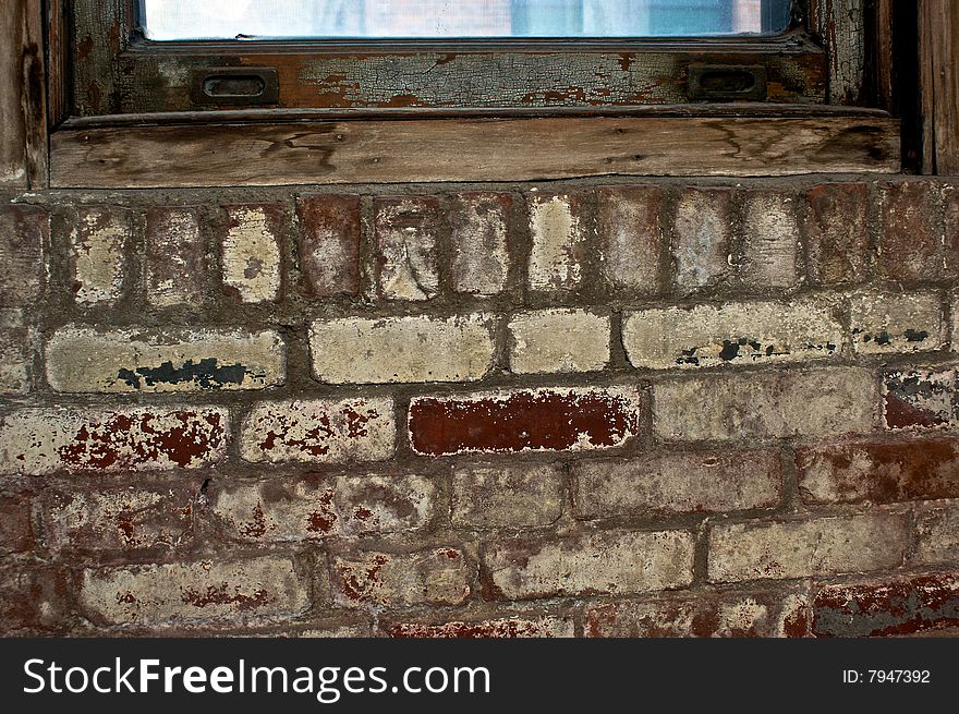 Old painted brick under rotting windowsill. Old painted brick under rotting windowsill