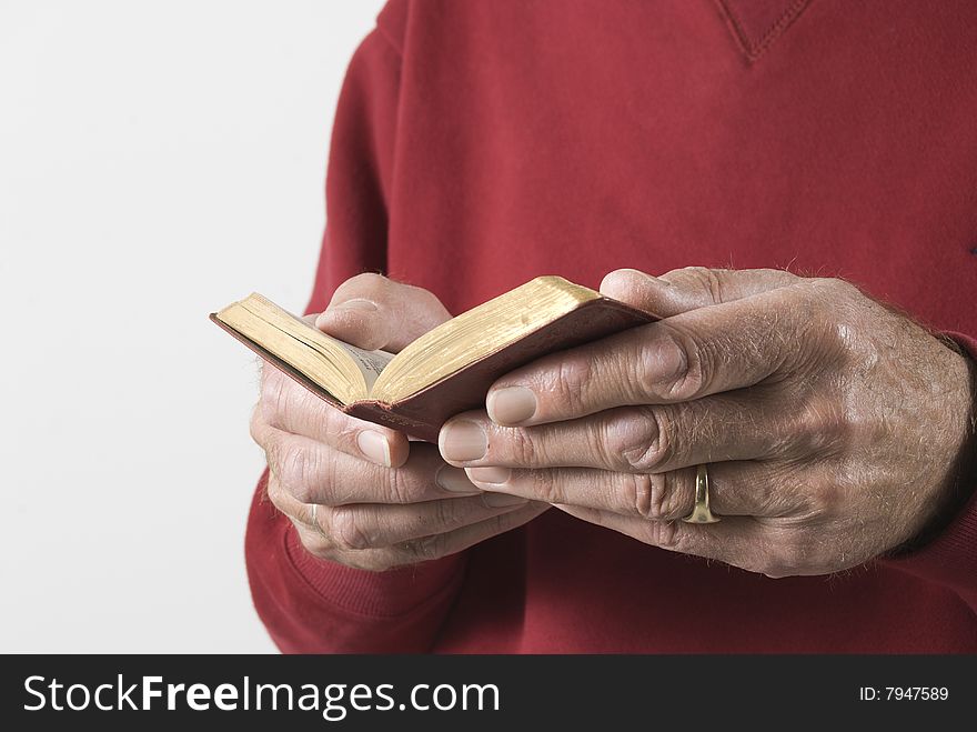 Close-up of senior male hands holding open prayerbook. Close-up of senior male hands holding open prayerbook