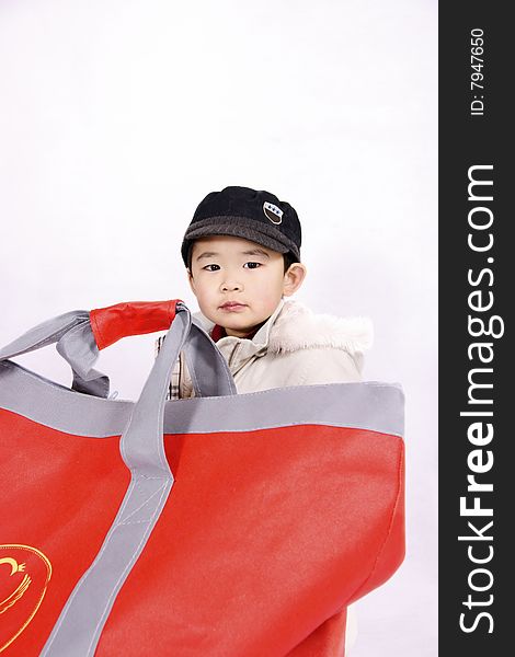 A picture of a pretty chinese boy going shopping carrying a big bag. A picture of a pretty chinese boy going shopping carrying a big bag