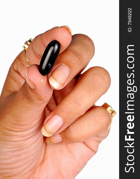 Hand holding a black capsule. Hand holding a black capsule.