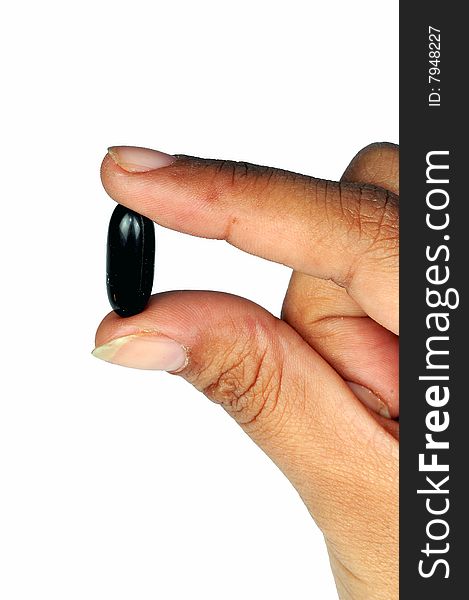 Hand holding a black capsule. Hand holding a black capsule.