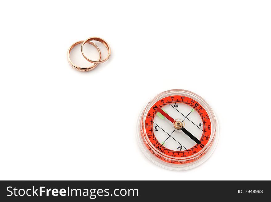 Isolated compass with golden wedding rings. Isolated compass with golden wedding rings