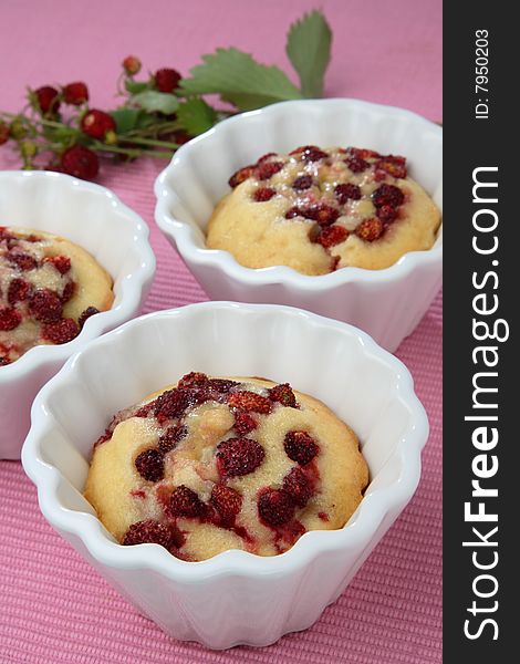 Strawberry muffins in white muffin bowls on table