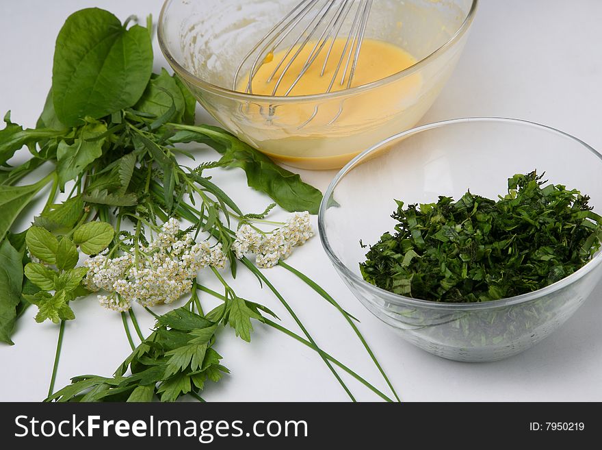 Cracked eggs and fresh herbs in bowls