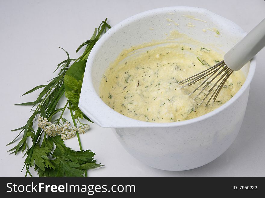 Cracked eggs and fresh herbs in bowls ontable