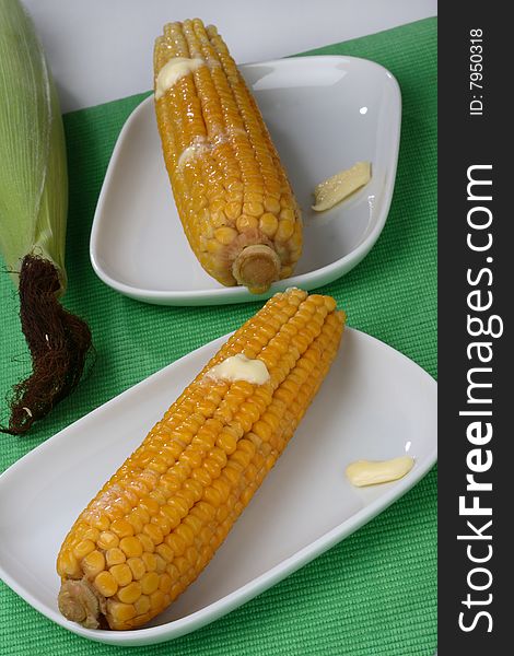 Boiled corn cob with butter on plate