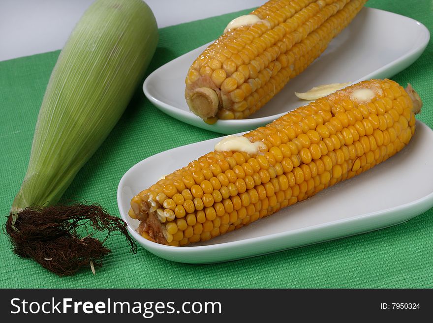 Boiled corn cob with butter on plate