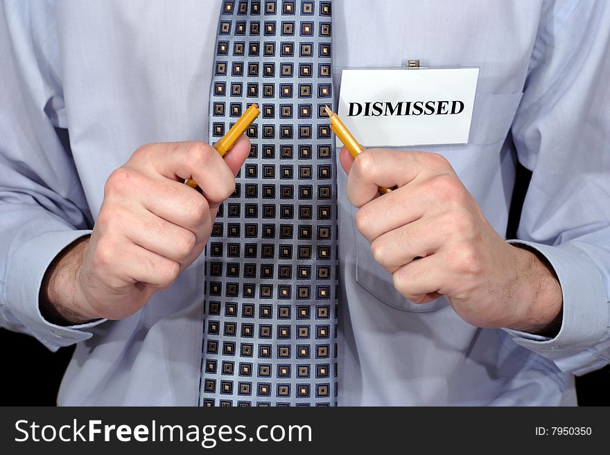 A fragment of the official styled person with badge DISMISSED and bloken pencil in hands. A fragment of the official styled person with badge DISMISSED and bloken pencil in hands.