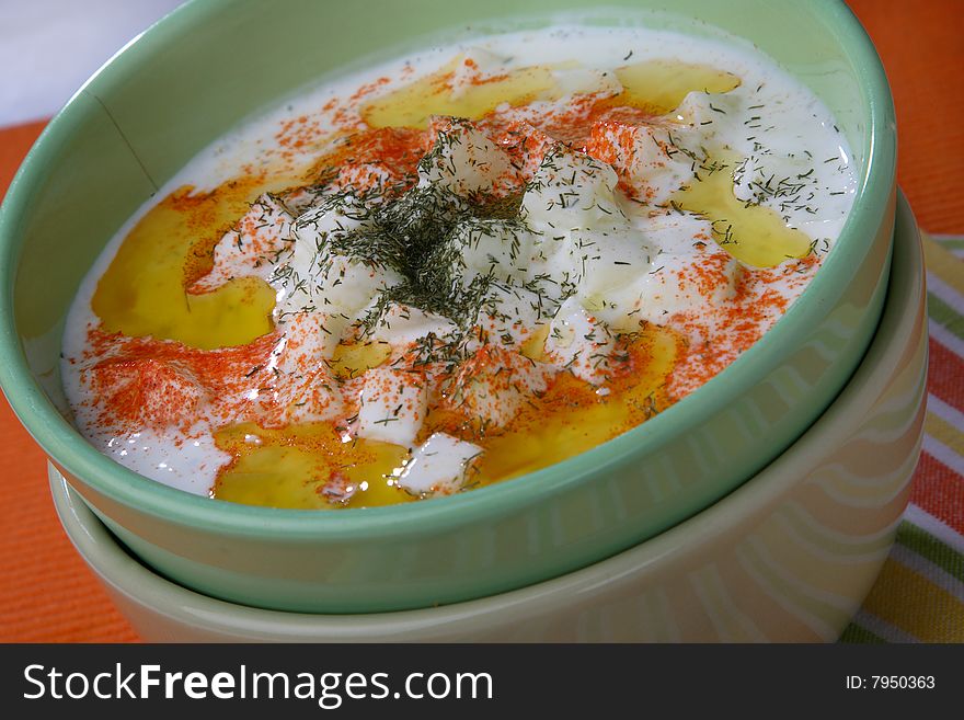 Cucumbers in cream with red pepper on plate