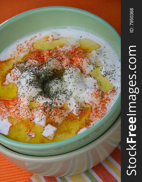 Cucumbers in cream with red pepper on plate