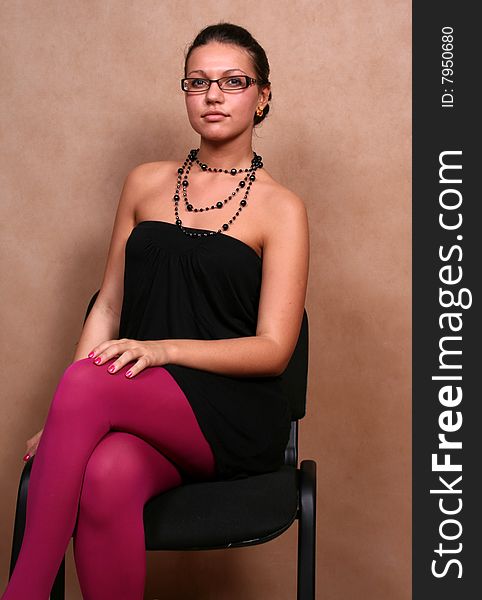 A girl in glasses sitting on a chair