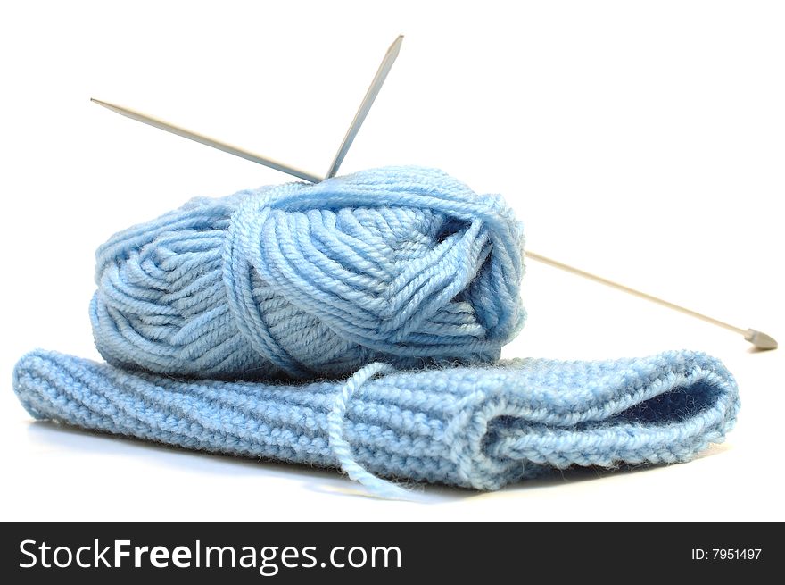 Two knitting needles, woollen yarn and knitting.