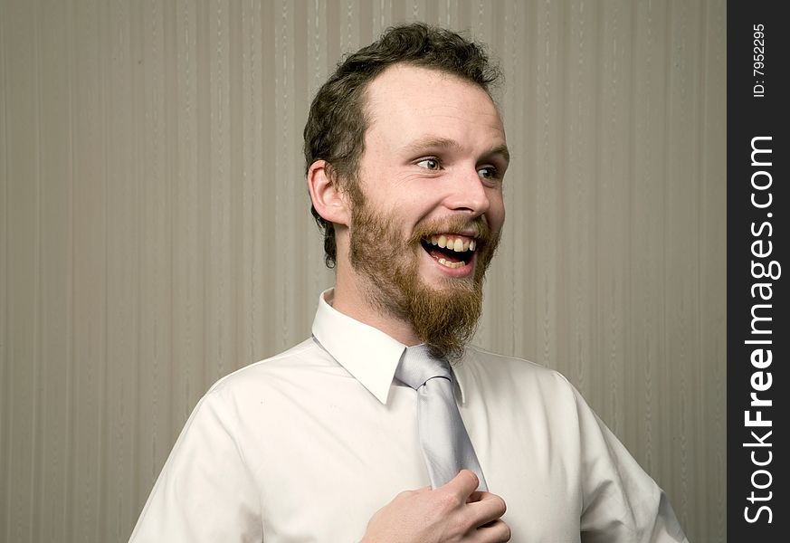 Young business man laughing while holding tie. Young business man laughing while holding tie