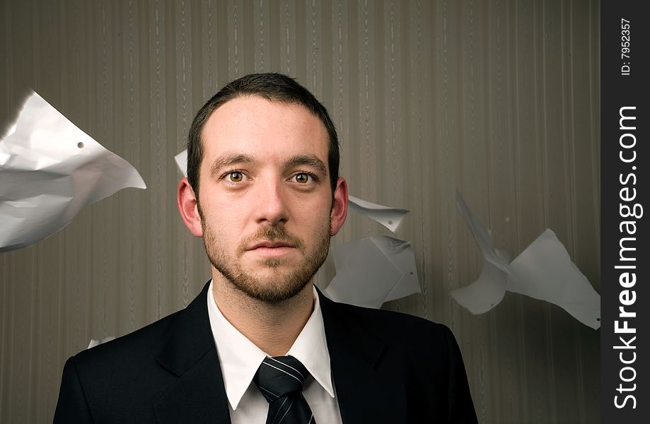 Young business man with paper blowing behind. Young business man with paper blowing behind