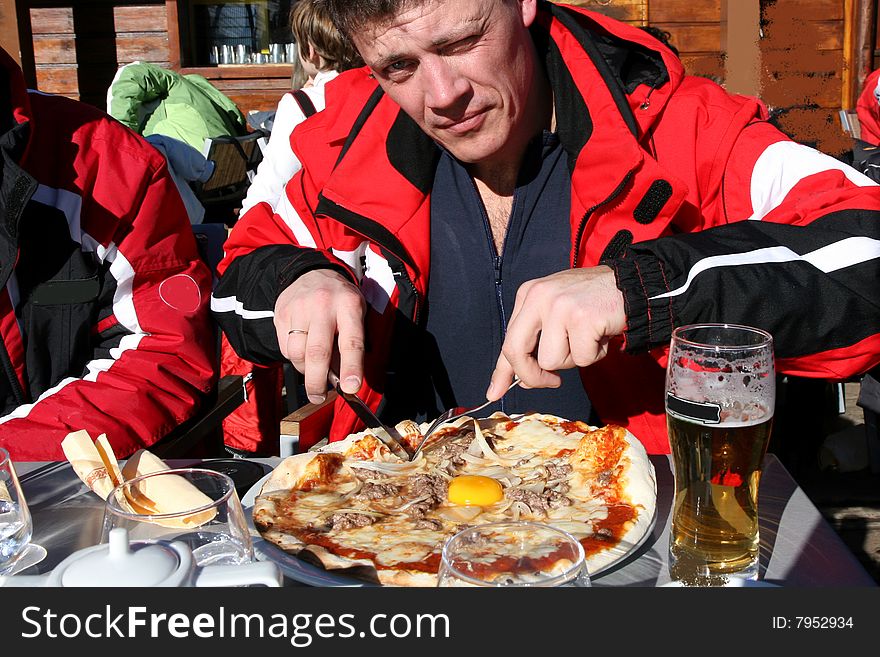 Men is eating pizza in the restautant on the sunny day. Men is eating pizza in the restautant on the sunny day