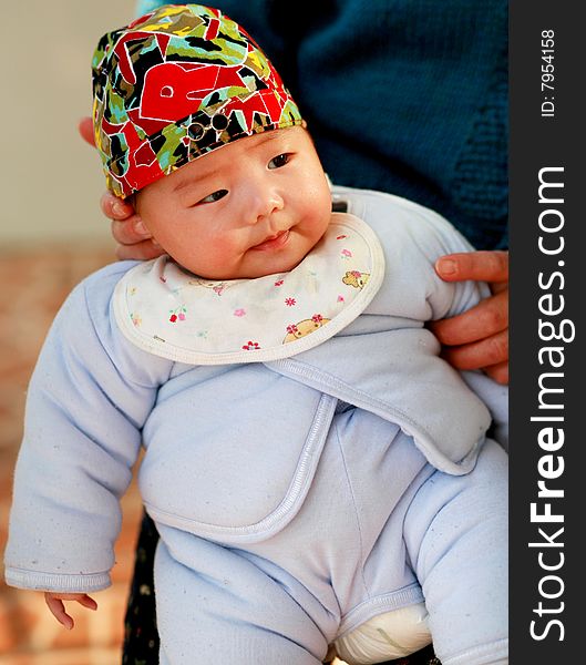 A sitting baby with sunshine on her face