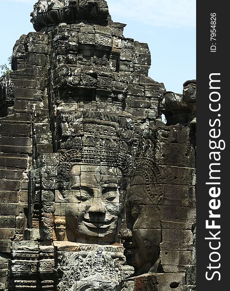 The contrast smile face of the stone sculpture in Bayon Wat,Siem Riep,Cambodia. The contrast smile face of the stone sculpture in Bayon Wat,Siem Riep,Cambodia