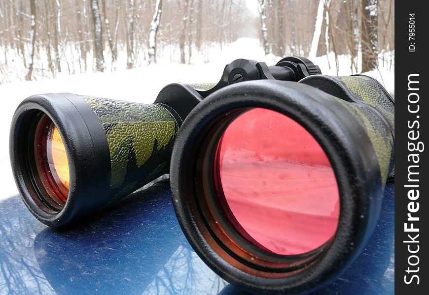 Binoculars with pink lenses on the bonnet of car