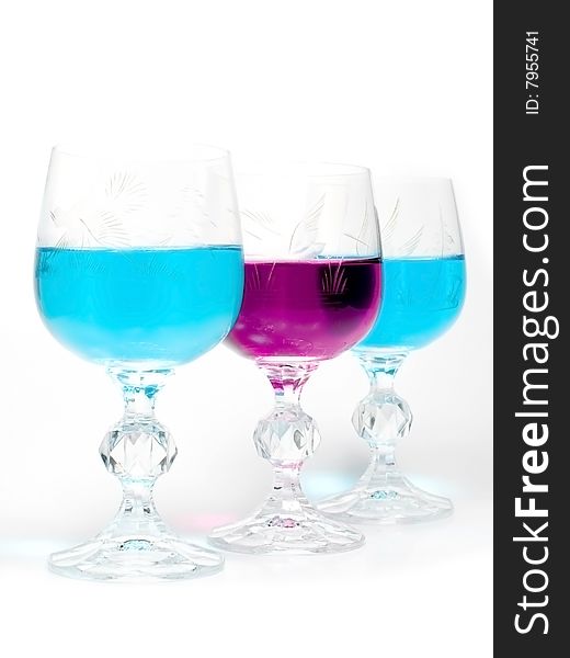 Three wineglass with drink blue and magenta colors