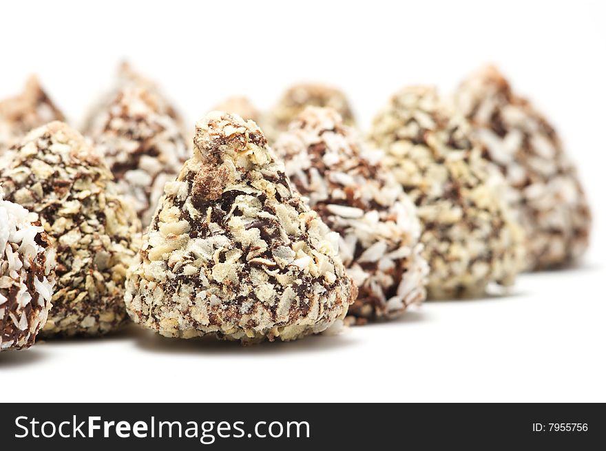 A row of chocolates isolated on a white background. Background blurry.