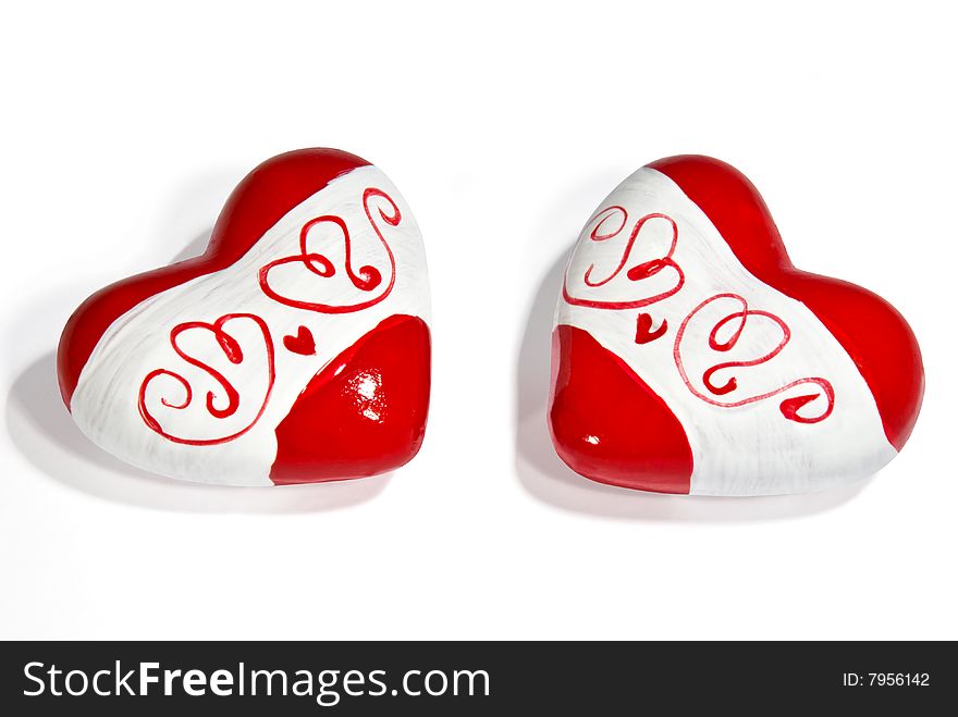 Two ceramic hearts with a pattern isolated on white background