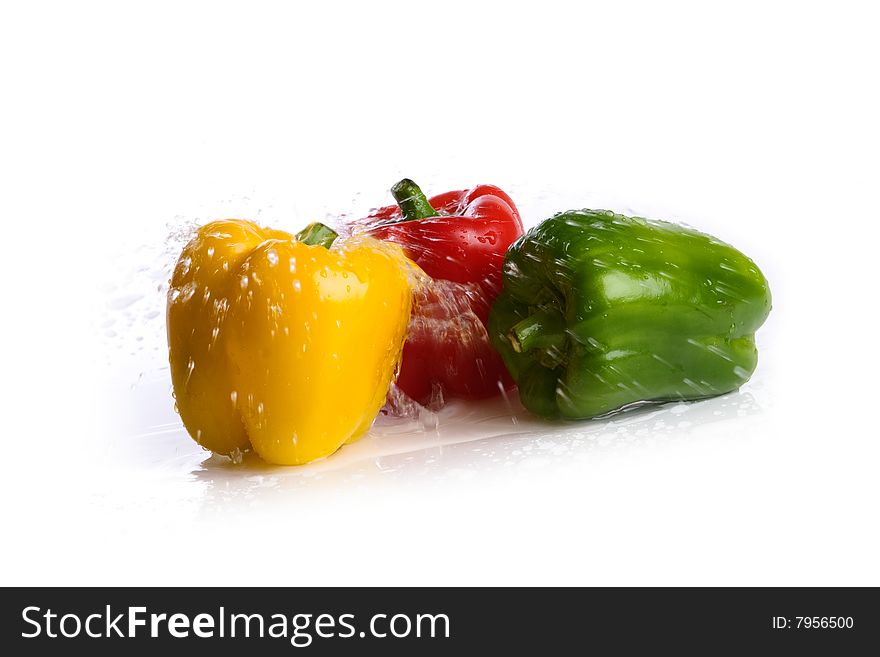 Three fresh peppers under pouring water isolated over white background