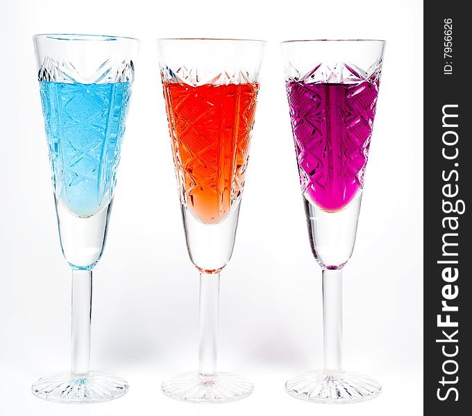 Three wineglass with drink blue, red and magenta colors
