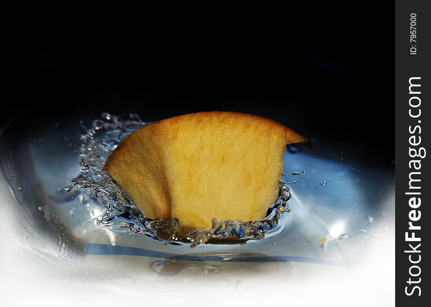 High-speed shooting of water with a slice of an apple falling in it