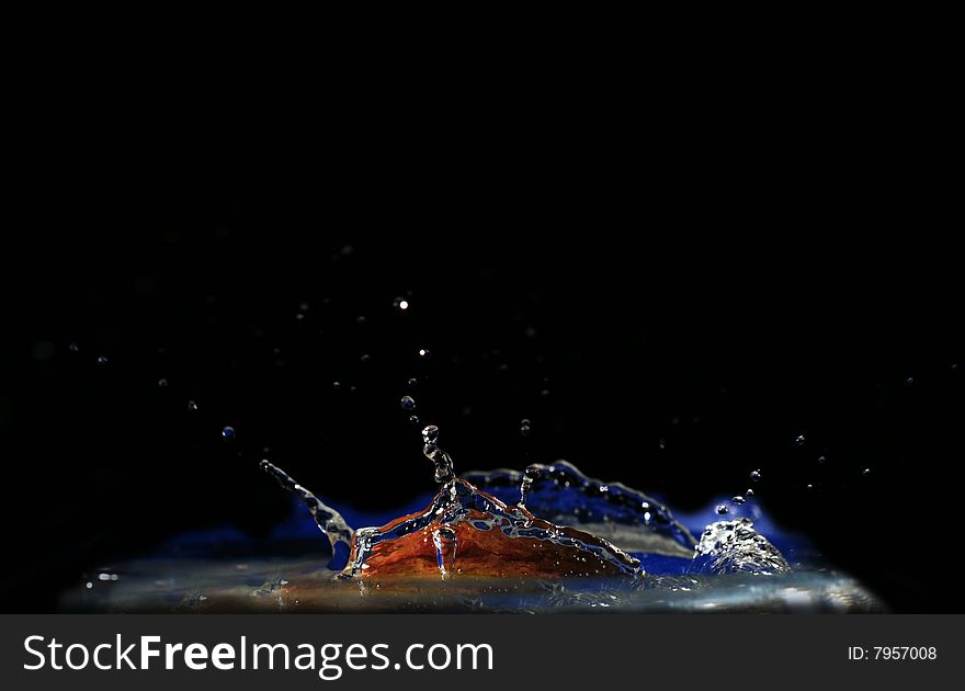 High-speed shooting of water with a slice of an apple falling in it