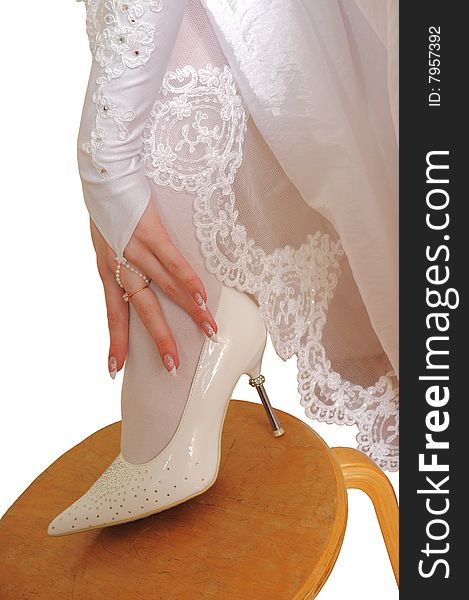 Hand of the bride in a glove and a white shoe it is isolated on a white background. Hand of the bride in a glove and a white shoe it is isolated on a white background.