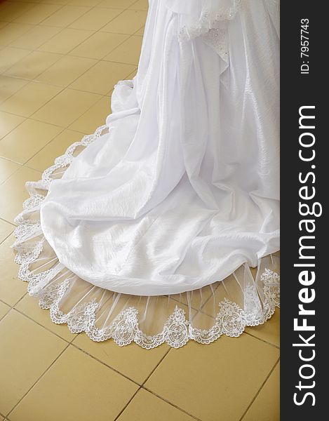 Loop of a wedding dress on a floor.