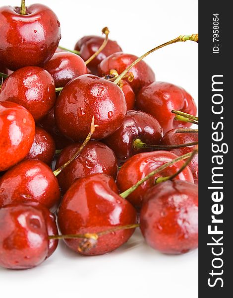 A pile of fresh cherries with stems on white. A pile of fresh cherries with stems on white