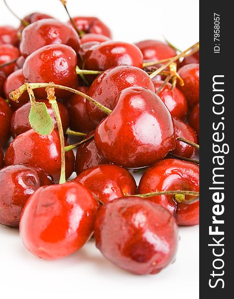 A pile of fresh cherries with stems on white. A pile of fresh cherries with stems on white