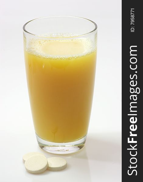 Glas of fizzy liquid with Effervescent tablets on bright background. Glas of fizzy liquid with Effervescent tablets on bright background