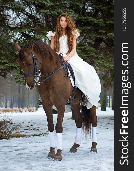 Woman in a white dress in winter on a horse. Woman in a white dress in winter on a horse