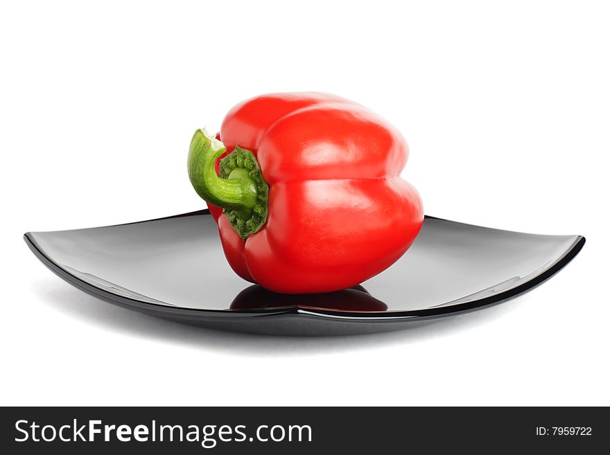 Red pepper on a black plate - isolated on the white background