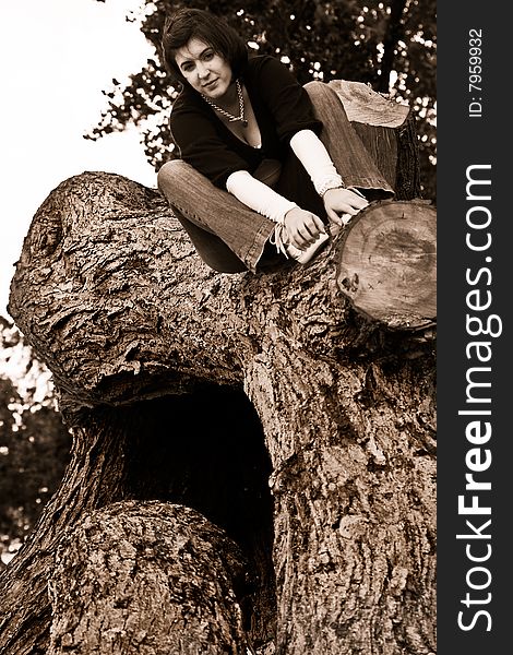 Portrait of a young female sitting on a fallen tree